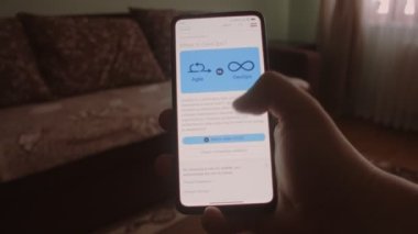 Devop 'lar. Cep telefonu ekranında DevOps hakkında bilgi okunuyor