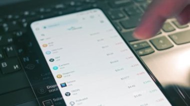 Kripto para ticareti şeması. Yatırımcı cep telefonu ekranında Dogecoin ve diğer altyazı para birimi fiyat indeksini kontrol ediyor. Hologram etkisi