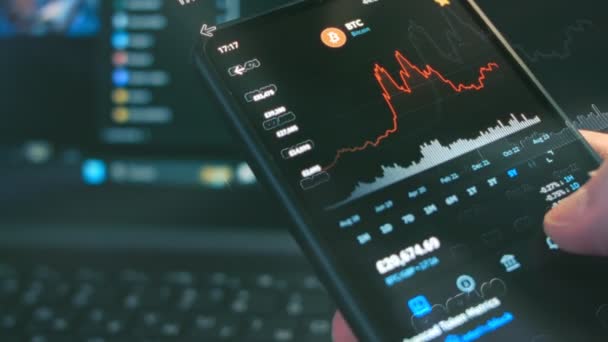仮想通貨取引チャート 投資家は 携帯電話の画面上のビットコインやその他のアルトコイン暗号通貨の価格指数をチェックします ホログラム効果 マクロビュー — ストック動画