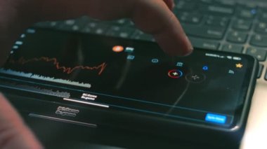 Kripto para ticareti şeması. Yatırımcı cep telefonu ekranında Bitcoin fiyat indeksi ve jeton ölçülerini kontrol ediyor. Hologram etkisi. Makro görünüm