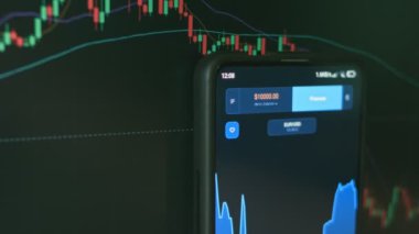 Akıllı telefon ve bilgisayar kullanarak yatırımcı finansal veri kripto borsasını, bozuk para fiyatını analiz ediyor. Çevrimiçi ticaret. Finansal endeksler zaman borsası duvarında aşağı yukarı değişiyor. Kripto para birimi kavramı