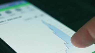 Akıllı telefon kullanan yatırımcı finansal veri kripto borsasını, bozuk para fiyatını analiz ediyor. Çevrimiçi ticaret. Kripto para birimi kavramı