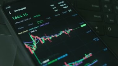 Cep telefonu ekranındaki şifreli veriler. Kripto para birimi konsepti. Piyasa fiyatlandırması. Bitcoin 'in finansal endeksleri ve alternatif madeni paralar zaman borsasının duvarında aşağı yukarı değişiyor. Hologram etkisi, makro