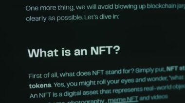 Bilgisayar ekranında NFT hakkında bilgi. Finansal olmayan Jeton NFT, sanat, video klipler, müzik ve daha fazlası gibi gerçek eşyaların mülkiyetini temsil eden eşsiz bir dijital varlıktır. Hologram etkisi