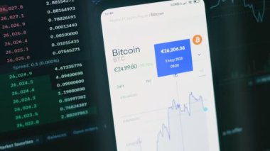 Cep telefonu ekranındaki şifreli veriler. Kripto para birimi konsepti. Piyasa fiyatlandırması. Bitcoin 'in finansal endeksleri zaman içinde borsa duvarında aşağı yukarı değişiyor. Hologram etkisi