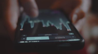 İşadamı, yatırımcı, tüccar, analizci, cep telefonu ekranındaki hisse senedi fiyatlarının grafiğine bakıyor. Banka yatırımı.