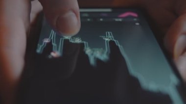 İşadamı, yatırımcı, tüccar, analizci, cep telefonu ekranındaki hisse senedi fiyatlarının grafiğine bakıyor. Banka yatırımı. Makro.