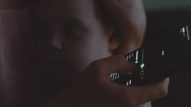 Tüccar yatırımcı, çocuğunu kucağında tutarken cep telefonu uygulaması kullanıyor. Finansal borsa analizleri. Yatırımcı grafik ticareti verilerini analiz ediyor. İş kadını çalışıyor ve onunla ilgileniyor.