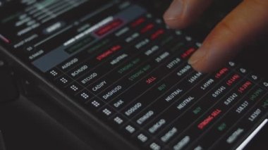 Tüccar yatırımcı analisti cep telefonu uygulaması kullanıyor. Kripto para birimi finansal borsası analizleri. Yatırımcı para birimi ve kripto para birimi fiyat indeksi listesini analiz ediyor. Makro görünüm