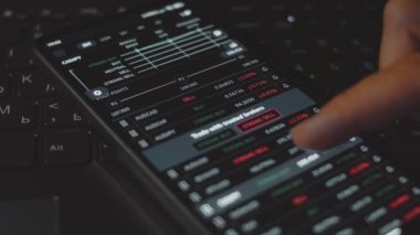 Tüccar yatırımcı analisti cep telefonu uygulaması kullanıyor. Kripto para birimi finansal borsası analizleri. Yatırımcı para birimi ve kripto para birimi fiyat indeksi listesini analiz ediyor. Makro görünüm