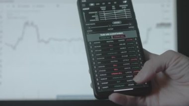 Ticari yatırımcı analisti cep telefonu uygulaması ve bilgisayar kullanıyor. Kripto para birimi finansal borsası analizleri. Yatırımcı para birimi ve kripto para birimi fiyat indeksi listesini analiz ediyor