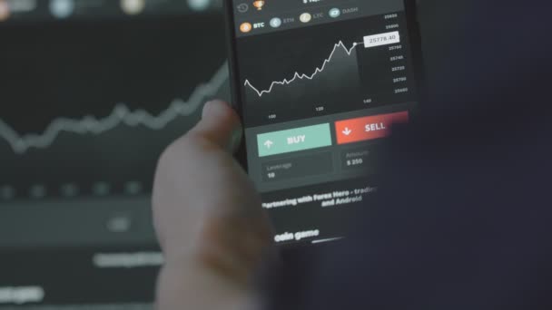携帯電話アプリとコンピュータを使用してトレーダー投資家アナリスト 仮想通貨金融株式市場のための分析 ビットコインの価格指数グラフを分析する投資家 — ストック動画