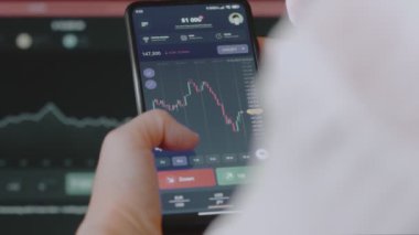 Cep telefonu ekranında finansal piyasa ve döviz kuru analiz ediliyor. Histogram büyüme ve fiyat endeksinde azalma gösteriyor. Yatırım kavramı