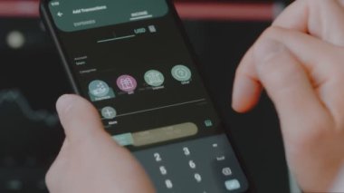 Akıllı para yönetimi. Bütçeyi izlemek için teknolojiyi kullanmak. Hesaplarını yapmak için cep telefonu kullanan biri. Gelir hakkında bilgi ekleniyor