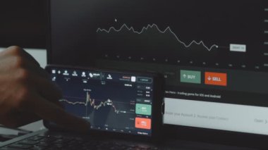 Cep telefonu ekranı ve bilgisayarda finansal piyasa ve döviz kuru analiz ediliyor. Histogram büyüme ve fiyat endeksinde azalma gösteriyor. Yatırım kavramı