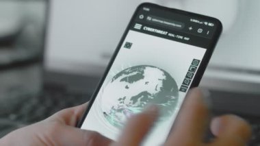 Dünya gezegeniyle küresel siber saldırı cep telefonu ekranında uzaydan görülüyor. İnternet ağı iletişimi siber saldırı altında. Çevrimiçi dünya çapında virüs yayılımı