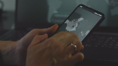 Cep telefonu ekranında dünya haritasıyla küresel siber saldırı, Avrupa. İnternet ağı iletişimi siber saldırı altında. Dünya çapında virüs yayılımı çevrimiçi. Yakın çekim.