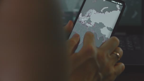 アジアの携帯電話画面で世界地図でサイバー攻撃 サイバー攻撃の下でのネットワーク通信 オンラインでウイルスの世界的な伝播 クローズアップ — ストック動画