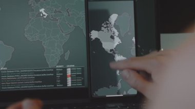 Cep telefonu ve bilgisayar ekranında dünya haritası olan küresel siber saldırı, ABD ve Avrupa. İnternet ağı iletişimi siber saldırı altında. Dünya çapında virüs yayılımı çevrimiçi. Yakın çekim.