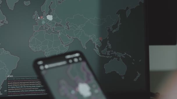 携帯電話とコンピュータ画面 ヨーロッパの世界地図による世界的なサイバー攻撃 サイバー攻撃の下でのネットワーク通信 オンラインでウイルスの世界的な伝播 クローズアップ — ストック動画