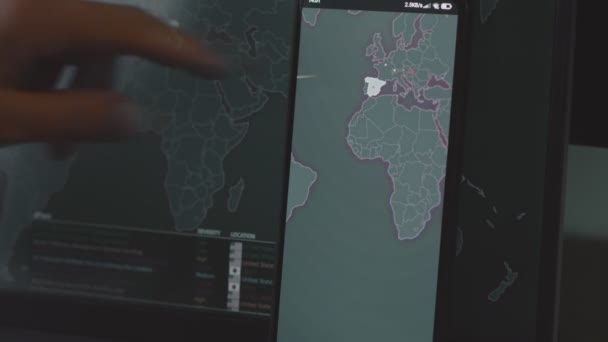 携帯電話とコンピュータ画面 ヨーロッパの世界地図による世界的なサイバー攻撃 サイバー攻撃の下でのネットワーク通信 オンラインでウイルスの世界的な伝播 クローズアップ — ストック動画