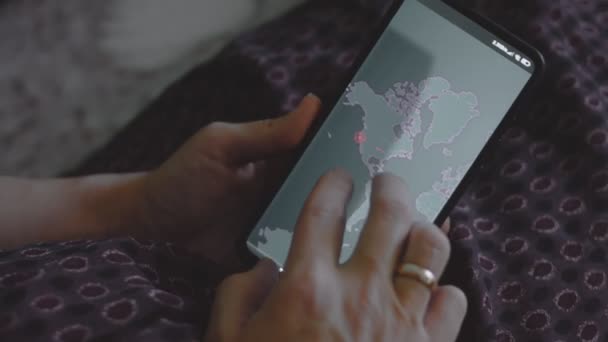 グローバルサイバー攻撃 携帯電話の世界地図を見ている女性 アメリカ サイバー攻撃の下でのネットワーク通信 オンラインでウイルスの世界的な伝播 — ストック動画