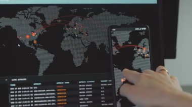 Cep telefonu ve bilgisayar ekranında dünya haritası olan küresel siber saldırı. İnternet ağı iletişimi siber saldırı altında. Çevrimiçi dünya çapında virüs yayılımı