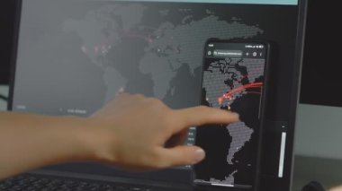 Cep telefonu ve bilgisayar ekranında dünya haritası olan küresel siber saldırı. İnternet ağı iletişimi siber saldırı altında. Çevrimiçi dünya çapında virüs yayılımı