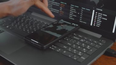 Cep telefonu ve bilgisayar ekranında dünya haritası olan küresel siber saldırı. İnternet ağı iletişimi siber saldırı altında. Dünya çapında virüs yayılımı çevrimiçi. Yakın çekim.