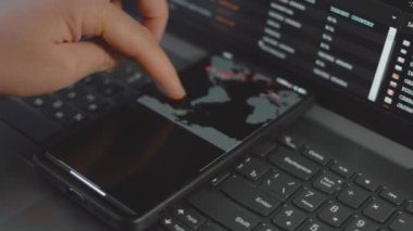 Cep telefonu ve bilgisayar ekranında dünya haritası olan küresel siber saldırı. İnternet ağı iletişimi siber saldırı altında. Dünya çapında virüs yayılımı çevrimiçi. Yakın çekim.