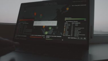 Bilgisayar ekranında dünya haritası olan küresel siber saldırı. İnternet ağı iletişimi siber saldırı altında. Dünya çapında virüs yayılımı çevrimiçi. - Yakın çekim. El bilgisayarı atışı