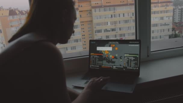 グローバルサイバー攻撃 コンピュータ画面で世界地図を見ている女性 サイバー攻撃の下でのネットワーク通信 オンラインでウイルスの世界的な伝播 ハンドヘルドシューティング — ストック動画