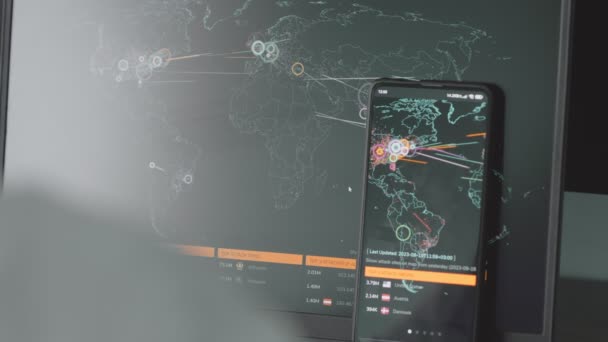 コンピュータおよび携帯電話のスクリーン上の世界地図による世界的なサイバー攻撃 サイバー攻撃の下でのネットワーク通信 オンラインでウイルスの世界的な伝播 クローズアップ — ストック動画