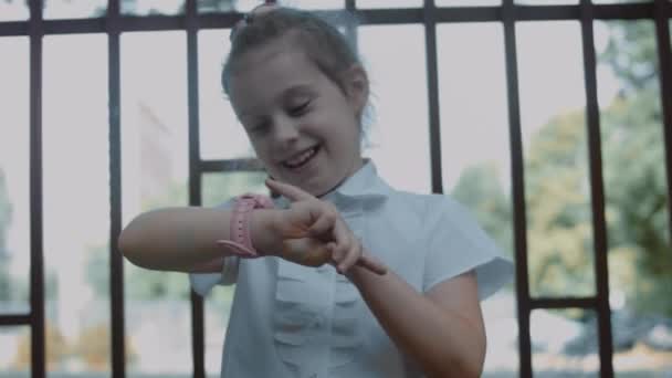 Lächelndes Süßes Schulmädchen Das Mit Der Smartwatch Spielt Fröhliche Jährige — Stockvideo