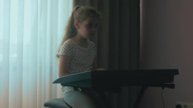 Kafkasyalı genç müzisyen kız eğlenceli aktiviteler yapıyor evde müzik eğitimi üzerine piyano dersi veriyor..