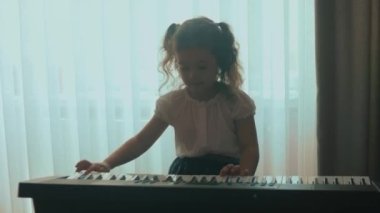 Kafkasyalı genç müzisyen kız eğlenceli aktiviteler yapıyor evde müzik eğitimi üzerine piyano dersi veriyor..