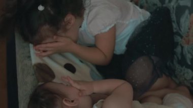 Kanepede oynayan iki tatlı kız kardeş. Peekaboo oyunu. Evde eğleniyorum.