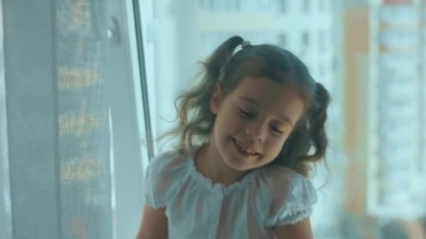 Schöne Lockige Mädchen Sitzt Auf Der Fensterbank Lächelnd Und Genießt — Stockvideo