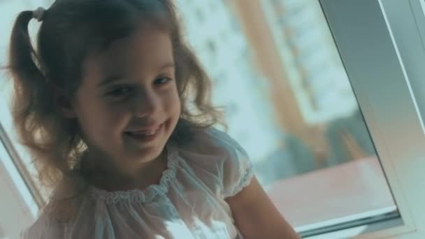 美丽的卷曲女孩坐在窗台上 我将对着相机微笑 享受她在家里的时光 — 图库视频影像