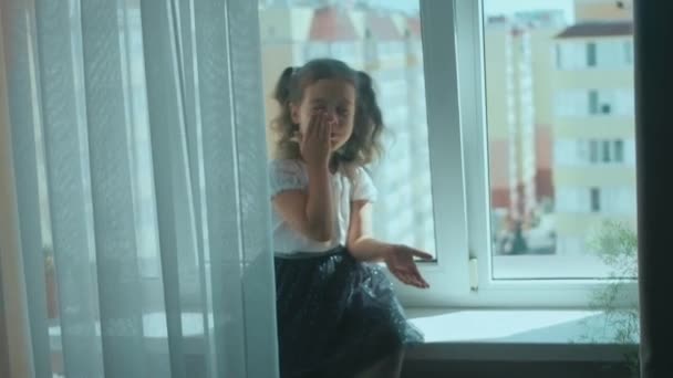 Güzel Kıvırcık Kız Evde Pencere Kenarında Oturmuş Gülümsüyor Hava Öpücüğü — Stok video