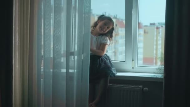 Красива Кучерява Дівчина Сидить Підвіконні Вдома Посміхається Танцює Насолоджуватися Вдома — стокове відео