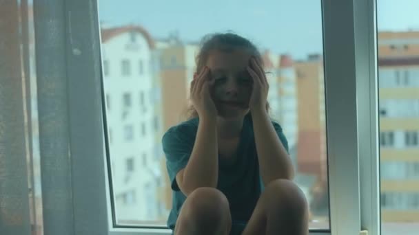 Λυπημένο Κοριτσάκι Που Κλαίει Ενώ Κάθεται Μόνη Στο Περβάζι Του — Αρχείο Βίντεο