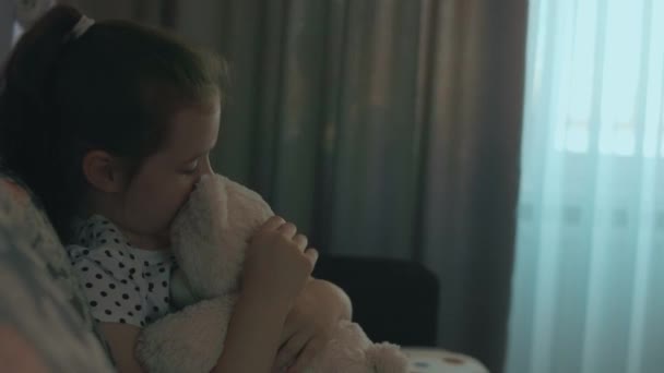 かわいい幸せな女子高生の少女はテディベアを抱擁し 彼女のお気に入りの玩具の友人を保持することを幸せに感じます 自宅でかわいい子供 ソファーに座っている — ストック動画