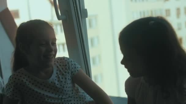 Két Nővér Szórakozik Beszélgetnek Mesélnek Ablakpárkányon Ülnek Nagy Ablak Mellett — Stock videók