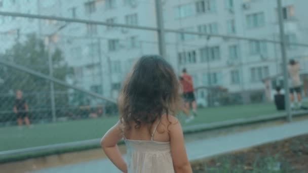 Ευτυχισμένο Κορίτσι Προσχολικής Ηλικίας Που Στέκεται Κοντά Ένα Γήπεδο Ποδοσφαίρου — Αρχείο Βίντεο