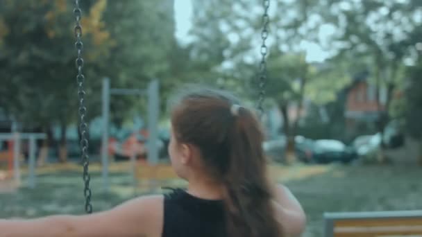 Güneşli Bir Yaz Gününde Parkta Salıncakta Sallanan Iki Mutlu Kız — Stok video