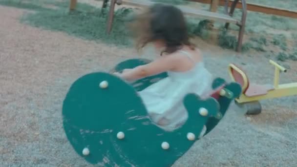 ロッキング馬の遊び場で楽しんでいる小さな幼稚園の少女 幼稚園のコンセプト 赤ちゃんの発達と早期 — ストック動画