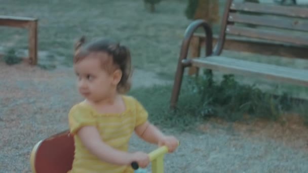 Felice Bambina Caucasica Siede Dondolo Metallo Sul Parco Giochi Una — Video Stock