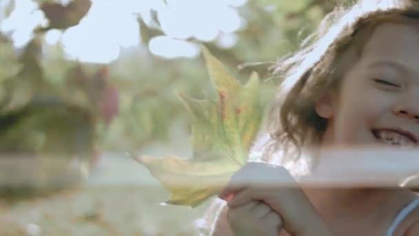 공원에서 잎으로 그녀의 얼굴을 드레스에 행복한 클로즈업 초상화 — 비디오