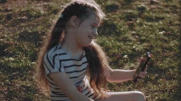 Portret Ładnej Dziewczynki Pasiastej Sukience Parku Poruszającej Się Smartfonie Lato — Wideo stockowe